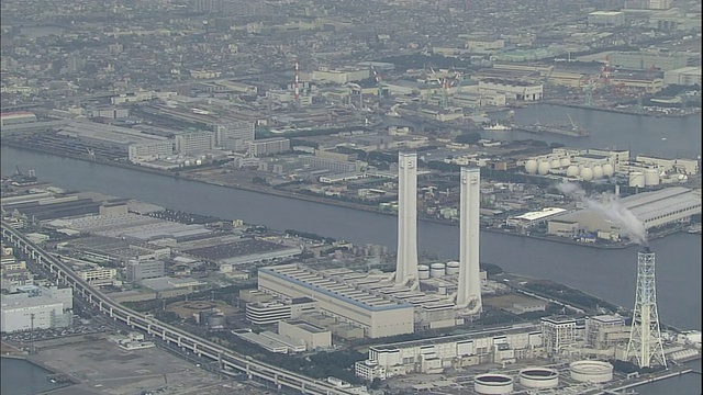 日本神奈川县的鹤江流过大国高速公路交汇处的一个热电厂的烟囱。视频素材