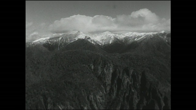 北海道大屿山火山群(Daisetsuzan volcano Group)的雪山上聚集着一堆蓬松的云。视频素材