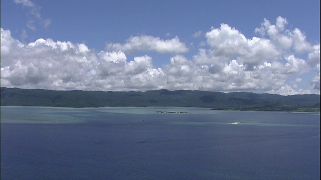 日本冲绳县附近的虹目岛和东海上空飘浮着蓬松的云朵。视频素材