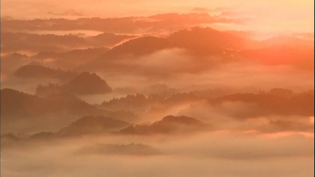 炽热的太阳从雾岛山和一片浓密的云海中升起。视频素材