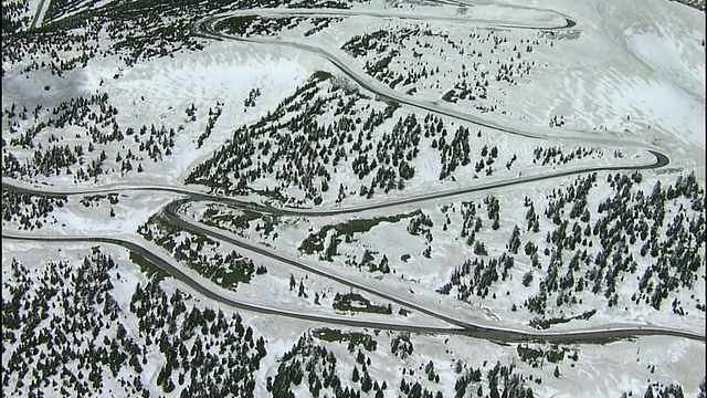 一条狭窄的道路蜿蜒穿过日本白雪覆盖的造山山脉。视频素材