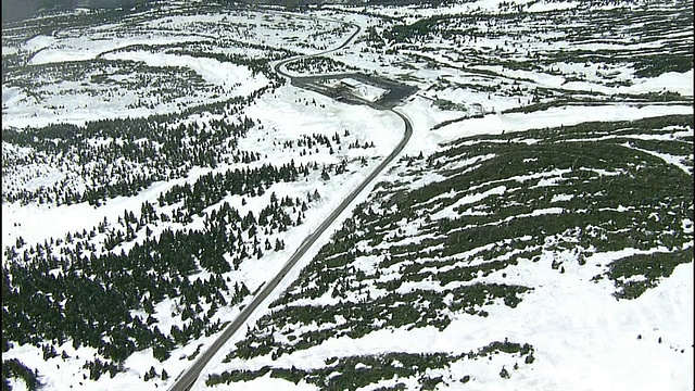 一条狭窄的道路蜿蜒穿过日本白雪覆盖的造山山脉。视频素材