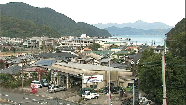 一座山耸立在日本Saiki湾附近的住宅区上。视频素材