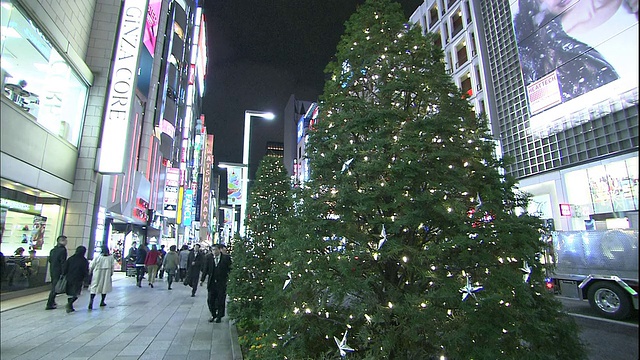 日本东京银座中央大街上，行人走过一棵圣诞树。视频素材