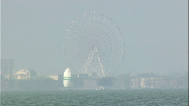 日本大津琵琶湖附近的摩天轮被海市蜃楼扭曲。视频素材