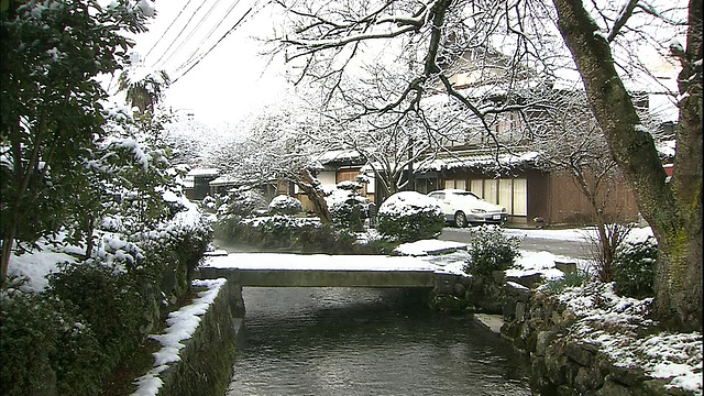 日本迈原市积藏河附近的一座房子和一座桥被积雪覆盖。视频素材