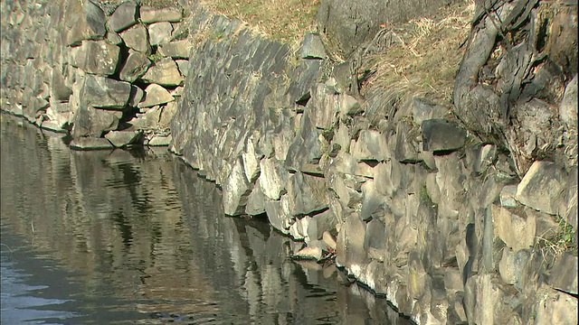 护城河水映照着长野松本城堡的石墙。视频素材