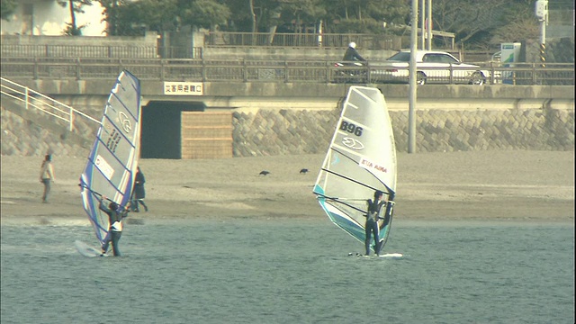 在日本祖西附近的相模湾，风帆冲浪者滑行过水面。视频素材