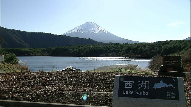 在日本山梨县的富士箱根伊豆国家公园，富士山隐现在斋子湖和它的标牌上。视频素材