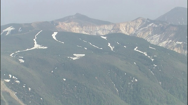 日本福岛的Adatara山郁郁葱葱的山坡上覆盖着一片片白雪。视频素材