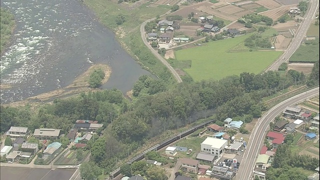 日本群马县，一辆复苏的蒸汽机车经过房屋和田野。视频素材