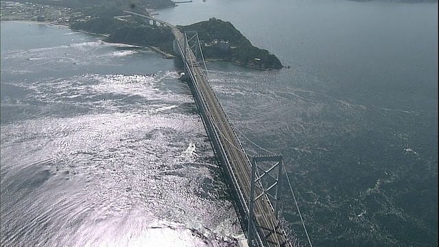 日本鸣人海峡，一艘游船在大鸣人大桥下的漩涡中行驶。视频素材