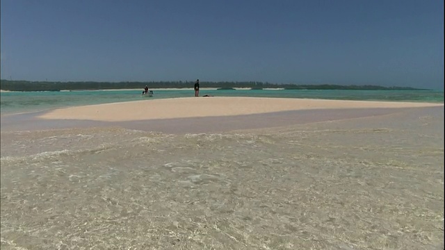 在日本鹿儿岛的约龙岛海岸，游客们站在一个只有在退潮时才会出现的白色沙洲附近视频素材