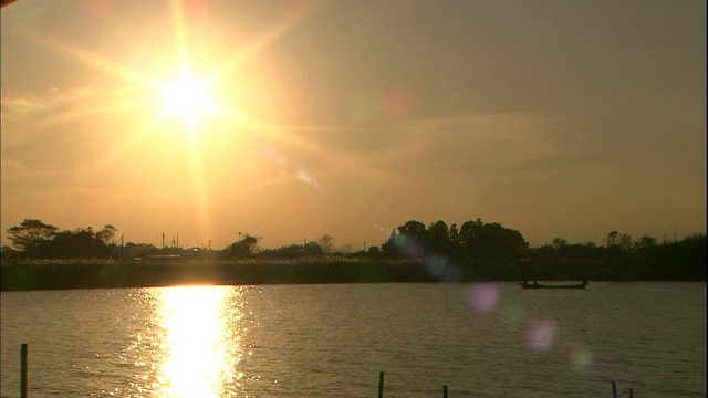 在日本茨城市的夕阳中，一艘船漂浮在中河上。视频素材