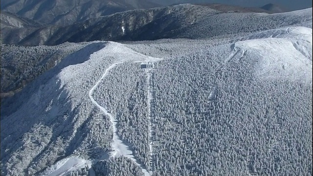 一条公路通向雪山，通往日本藏山山脉的索道站。视频素材