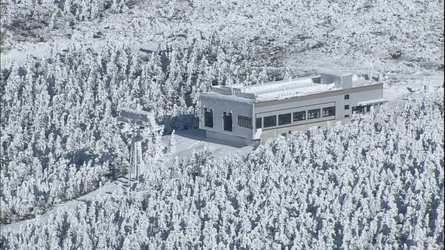 在日本藏山山脉，霜冻的森林环绕着一个索道站。视频素材