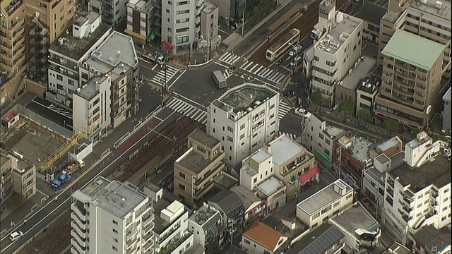 一辆陶登荒川线有轨电车驶离乘客站台，驶往十字路口。视频素材