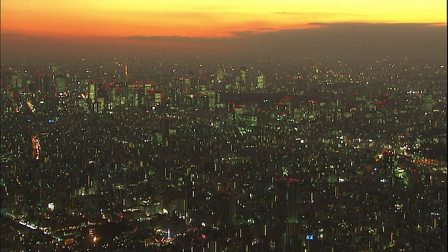 在日本东京，东京天空树塔和周围的高层建筑在夜晚闪闪发光。视频素材