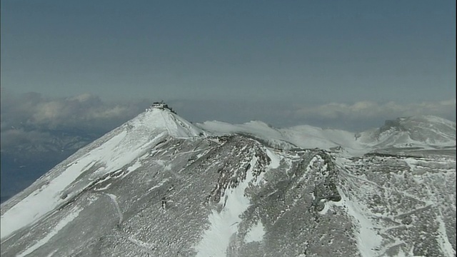 一个废弃的气象站坐落在白雪皑皑的富士山山顶上。视频素材