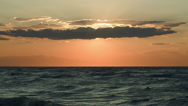 波涛汹涌的大海和被云遮蔽的夕阳视频素材