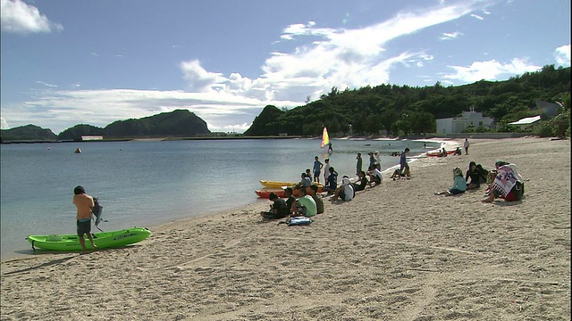 游客们在日本Chichijima岛的沙滩上休息。视频素材