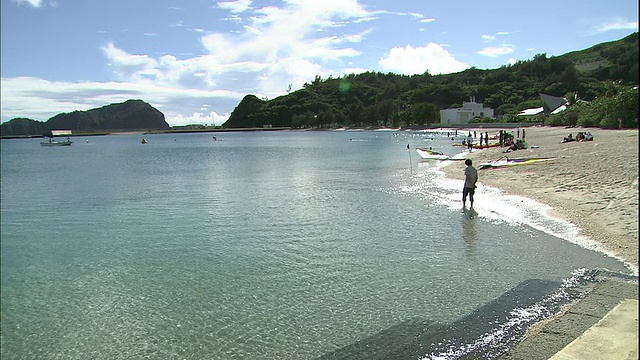 一名游客在日本Chichijima岛的太平洋中涉水。视频素材