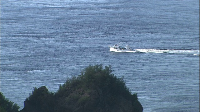 一艘船从日本Chichijima岛附近的双美湾驶离海岸。视频素材