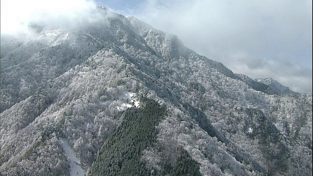 乌云笼罩着白雪覆盖的石冢山。视频素材