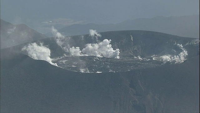 雾岛山脉(Kirishima Mountain Range)的欣莫山(mount . Shinmoe)火山口冒出缕缕浓烟。视频素材