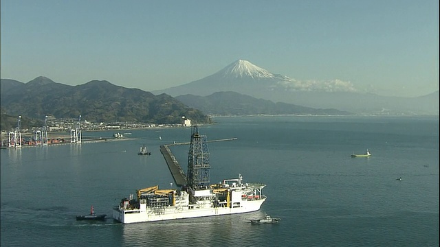 当深海钻探船Chikyu号驶离清水港时，富士山耸立在地平线上。视频素材