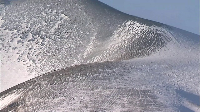 一缕白色的羽毛在日本浅山的雪峰上翻腾。视频素材