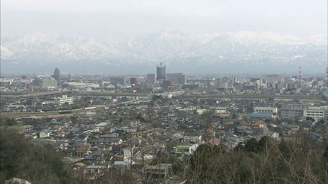 富山市沿着积雪的日本tatateyama山脉的山脚延伸。视频素材