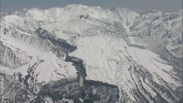 雪覆盖了崎岖的山坡和山峰上的鹤木山和Tateyama在日本。视频素材