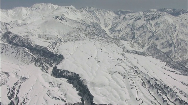 田山黑袍山路蜿蜒于日本田山山脉的雪坡上。视频素材