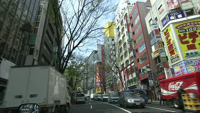 车辆驶过东京道根坂大街上的酒店、商店和办公楼。视频素材