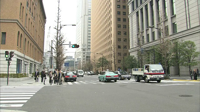 在日本东京丸之内区，车辆经过高层建筑。视频素材