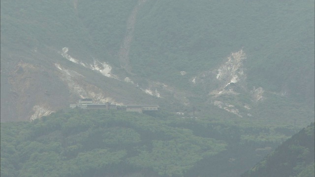 火山蒸汽充满了日本箱根最高的山神山下树木繁茂的山谷。视频素材