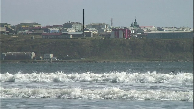 在国志里岛一个村庄的山顶附近，海浪沿着海岸线起伏。视频素材