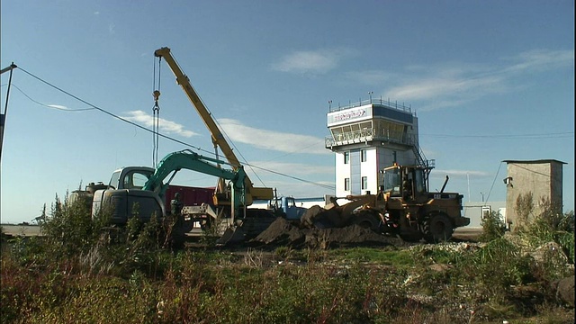 在国内岛门捷列耶沃机场附近的一处建筑工地，一辆电动铲车和推土机正在铲土。视频素材