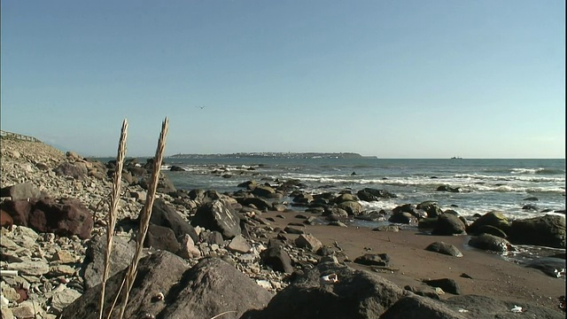 在国志里岛的海滩上，海浪拍打着巨石。视频素材