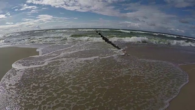 在晴朗的阴天，海浪拍打着海岸视频素材