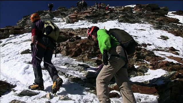 导游和攀登者正在攀登马特洪峰的一个多雪的岩石斜坡视频素材