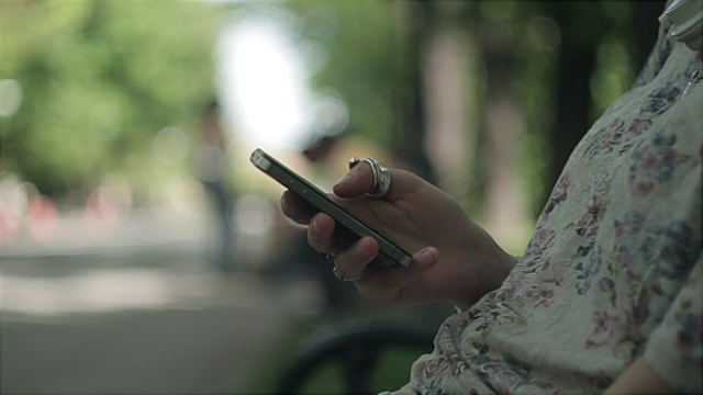 年轻女子，智能手机，iphone，浏览，互联网，触摸屏，长凳，公园，散景视频下载