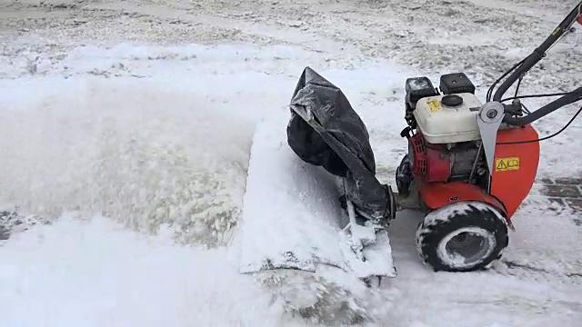 冬天，吹雪机清理人行道上的积雪。手持。视频素材