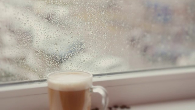 咖啡杯对着下雨天的窗户视频素材