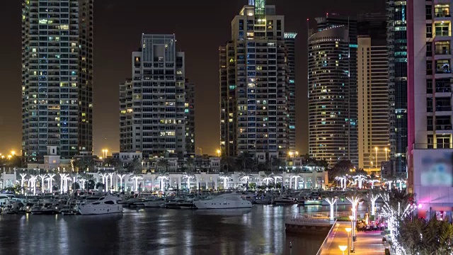 阿联酋迪拜码头的海滨长廊和运河在夜晚缓缓流逝视频素材