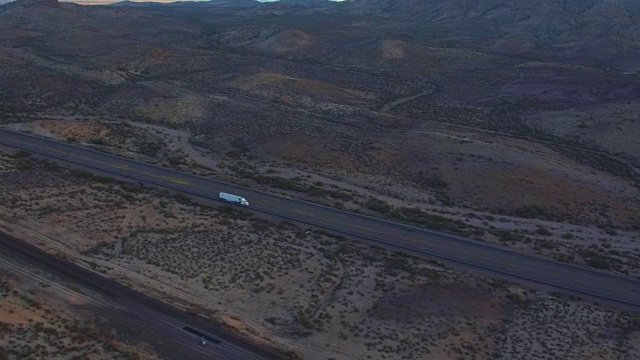 空中摄影:在空旷的高速公路上，在运送货物的半挂货车上空飞翔视频素材