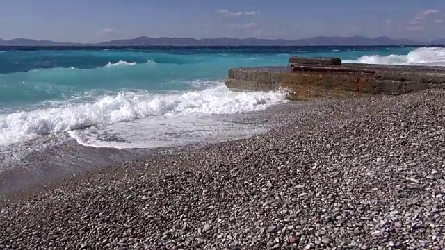 波浪拍打着布满卵石的海岸，形成一个码头视频素材