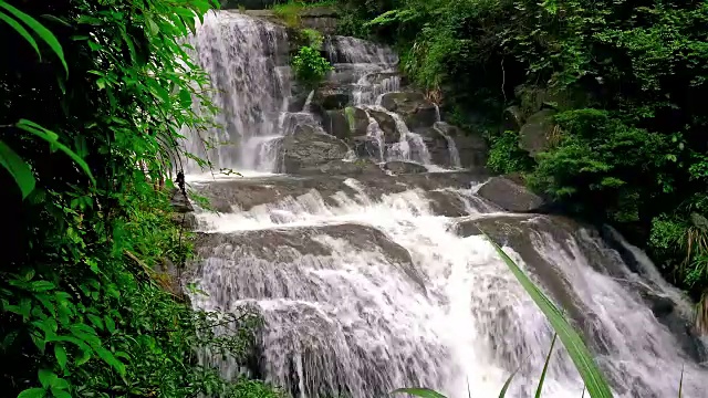 强大的瀑布在长满苔藓的岩石上运行，带有4K的声音视频素材