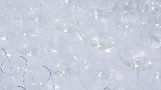白色桌布上放着许多空杯子。玻璃器皿微距特写视频素材